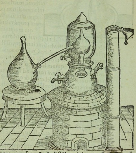 A historical woodcut illustration of an early distillation apparatus associated with Mary the Jewess (Maria Prophetissima), one of the earliest known alchemists. A bulb-shaped flask is heated beside a water-filled vessel supporting an alembic, with connecting tubes allowing vapours to condense. The arrangement illustrates the principle behind the bain-marie, or water bath, a gentle heating method still widely used in professional and domestic kitchens today.