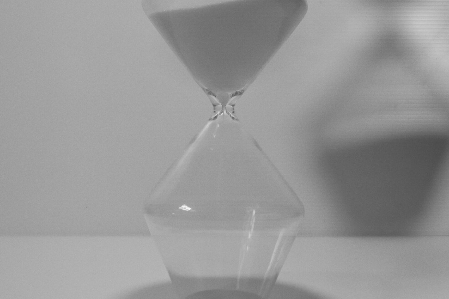 Minimalist glass counter filled with white sand, set against a plain white background with a soft shadow.